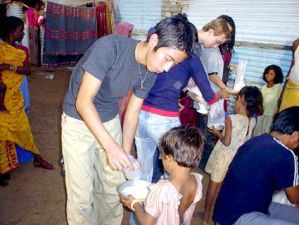 買った食材を、スラムの子供達に配る若者達